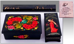 Two Russian Lacquered Decorated Boxes. One with floral decoration, the other depicting a Russian