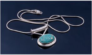 Silver Modernist Pendant Set With An Oval Turquoise Suspended On A Snake Link Chain.