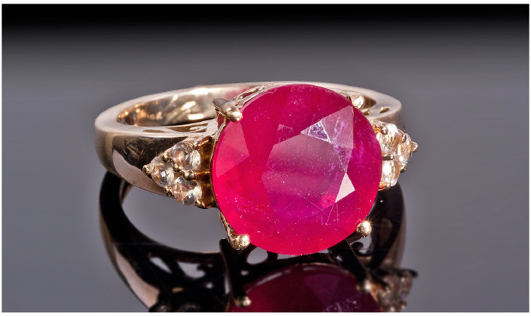 9ct Gold Dress Ring Set With A Central Round Cut Ruby Coloured Stone Between White Faceted Stones,