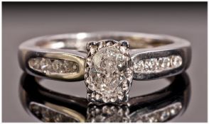 platinum Set Single stone Diamond Ring. The oval shaped diamond of good colour, with eight small