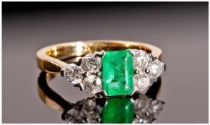 18ct Gold Set Emerald and Diamond Ring. The emerald of very good colour flanked by 6 diamonds, also