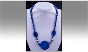 Lapis Lazuli And Silver Necklace, comprising flat oval and round lapis beads, centred by a large