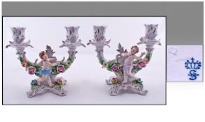 Sitzendorf Figural Pair Of Two Branch Candlesticks, with putti and floral decoration to each. Circa
