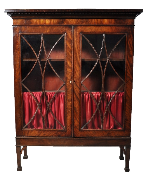 Mahogany bookcase, dentil cornice, two glazed doors with elliptical bars enclosing shelves on a