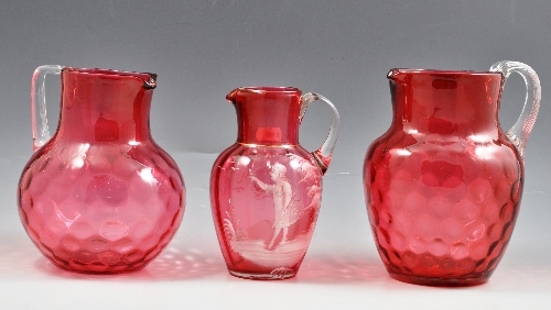 Two Cranberry glass jugs, honeycomb moulded, 19cm and 18cm, nine other Cranberry jugs and a