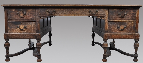 A large Edwardian oak twin pedestal desk, rectangular top with a tooled set leather inset, fitted