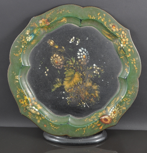 A Victorian papier mache circular tray, serpentine moulded edge, painted with flowers on a green