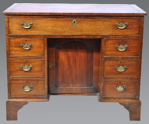 A George III mahogany kneehole desk, rectangular top with a tooled leather inset, fitted with a