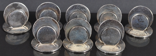 A set of silver menu stands, by S Morden & Co., London 1928, disk form, circular bases, 3cm. (8)