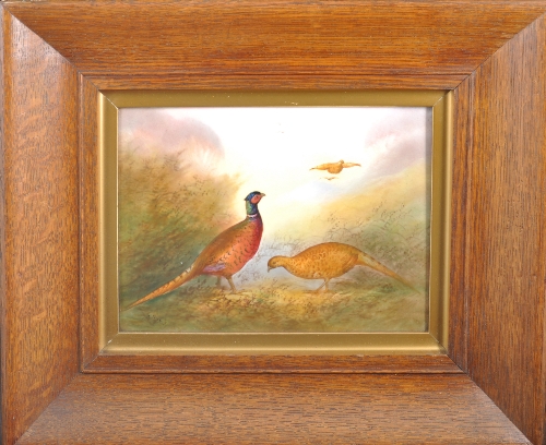 A Fieldings Crown Devon pottery plaque, painted with pheasants in a landscape by R Hinton, 18cms x