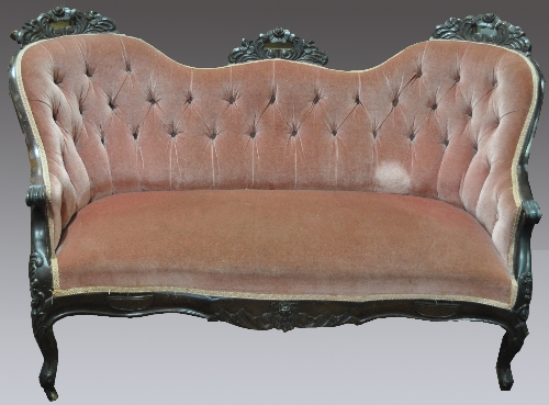 A Victorian style mahogany settee, chair-back ends, foliate and scrolled crestings, upholstered in