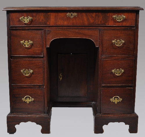 A George III mahogany kneehole dressing table, rectangular top with crossbanding, fitted with a