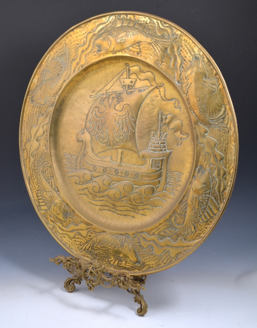 An Arts and Crafts brass charger, circa 1900, in the manner of John Pearson, the field hammered