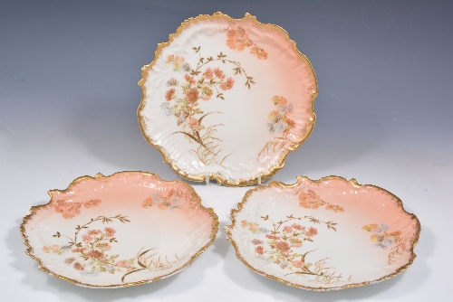 Three Limoges dessert plates, M, Redon, late 19th Century, floral decoration, on a peach ground,