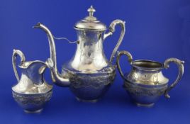 An early 20th century Chinese silver three piece coffee set, of urn form, engraved and embossed with