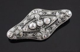 A 1920`s platinum and gold, diamond set brooch, of shaped oval pierced openwork design, set with