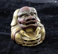 A fine Japanese gilt lacquer netsuke of a boy wearing a dragon costume, Meiji period, with red