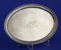 A George III silver oval teapot stand, with engraved armorial and beaded border, on four claw and