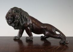 A Japanese bronze figure of a lion, early 20th century, with its body outstretched, unsigned, 33cm.