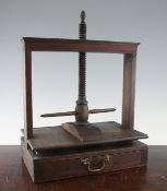 An 18th century mahogany table top linen press, with adjustable screw thread and single base drawer,