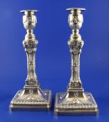 A pair of 1970`s Adam design silver candlesticks, with tapering stems and decorated with ram`s