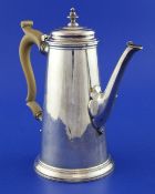 A George II silver coffee pot, of tapering form, with turned finial, panelled spout and wooden