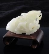 A Chinese white jade figure of a recumbent deer, 17th / 18th century, grasping a sprig of lingzhi