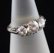 An Edwardian 18ct gold and graduated three stone diamond ring, with pierced scroll setting and an