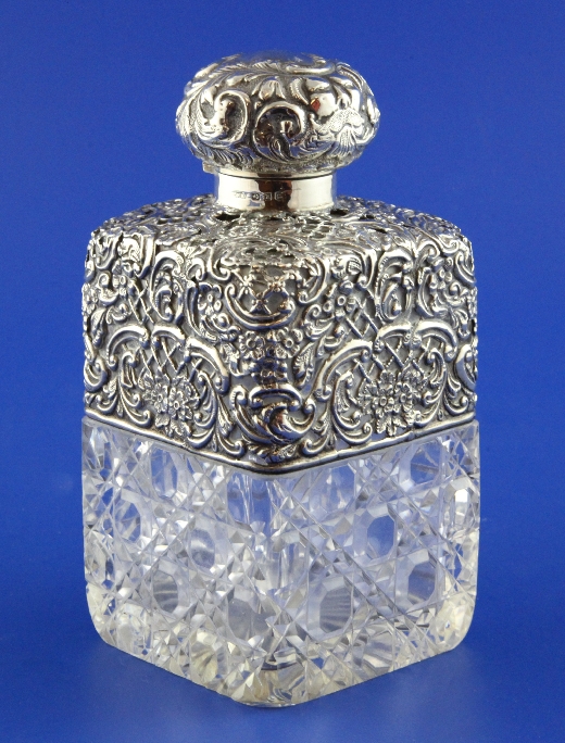 A late Victorian silver mounted hobnail cut glass decanter shaped scent bottle, with scroll and