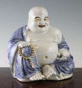 A Chinese blue and white seated figure of Budai, Republic period, with colouring to his face,