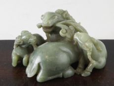 A Chinese green jade group of three rams, 17th / 18th century, all in recumbent pose, the largest
