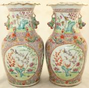 A pair of Chinese Canton decorated famille rose vases, painted with birds amid rockwork and