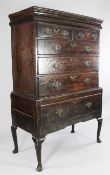 An 18th century oak chest on stand, with concealed moulded drawer above an arrangement of six