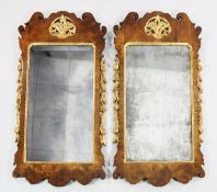 A pair of George II walnut and parcel gilt wall mirrors, each with a pierced acanthus motif and