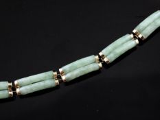 A 14ct gold and jadeite bracelet, with six double curved bar links and Chinese character clasp,