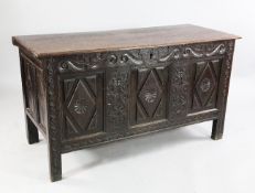 A carved oak coffer, with triple lozenge panel fronts with guilloche and scrolling decoration, W.4ft