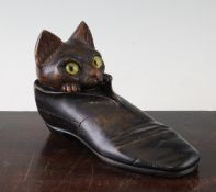 A late 19th / early 20th century Black Forest carved inkwell, modelled as a cat in a shoe, with