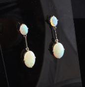 A pair of silver and white opal drop earrings, each set with two graduated oval opals, 1.5in.