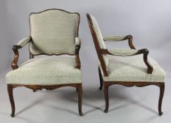 A pair of provincial French Louis XV beech fauteuil chairs, with patterned upholstery, open arms and