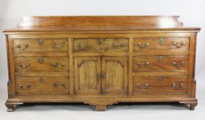A George III mahogany dresser base, with reeded quarter pillar sides, fitted an arrangement of seven