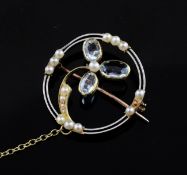 An early 20th century gold, aquamarine and seed pearl set brooch, of open circular form, with