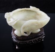 A Chinese celadon jade `peach` cup or brushwasher, Ming dynasty, of peach form carved in relief with