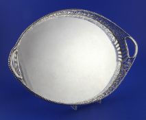 An Edwardian pierced silver oval gallery tray by Charles Stuart Harris, with inset handles, beaded