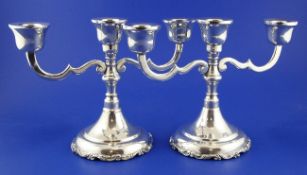 A pair of Mexican sterling silver two branch, three light dwarf candelabra, with scroll arms, 7in,