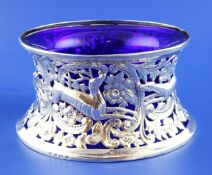 An Edwardian silver dish ring with blue glass liner, pierced and decorated with hounds, stag and