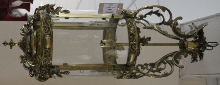 A Victorian style brass hanging hall lantern, with pierced acanthus C scrolls and shaped glass
