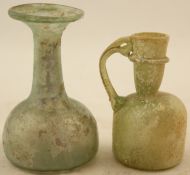 Two Roman glass vessels, 1st century AD, the first a bottle shape flask, 3.5in., the second a jug,