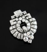 An Art Deco white gold and diamond set brooch, of stepped and round design, set with round, baguette