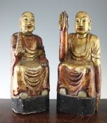 Two Burmese polychrome camphorwood figures of Buddha, both seated, the first holding a model of a