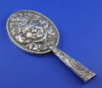 A Victorian embossed silver hand mirror, decorated with satirical mask amongst scrolls, Rosenthal,